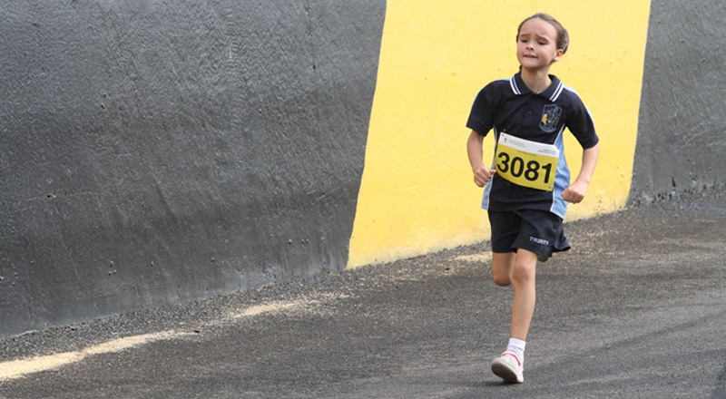 One of 39 students that represented Trinity Catholic Primary at the Parramatta Diocesan Cross Country at Sydney Motor Sports Park. The student is sprinting.